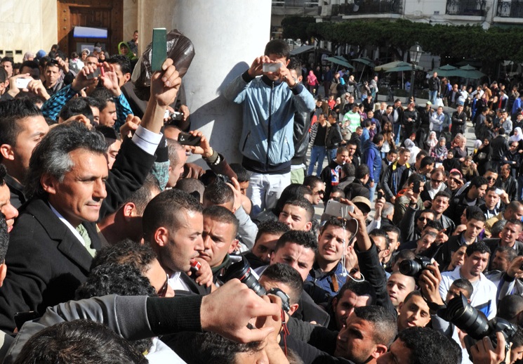 Rachid Nekkaz exhibant son passeport algérien à Alger, en mars 2014. New Press